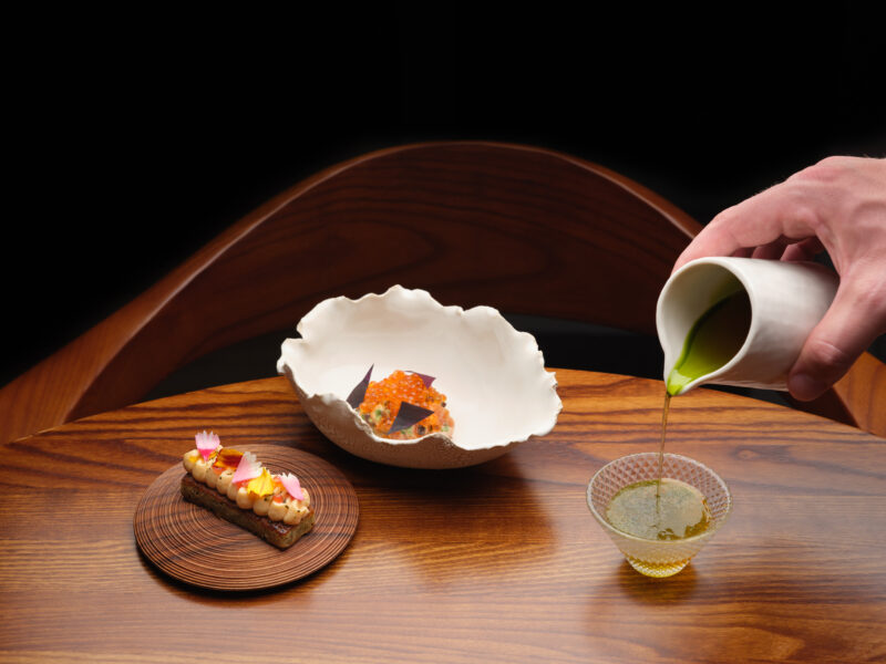 trout dish at SOURCE, served with delicate garnishes as a green sauce is poured tableside.
