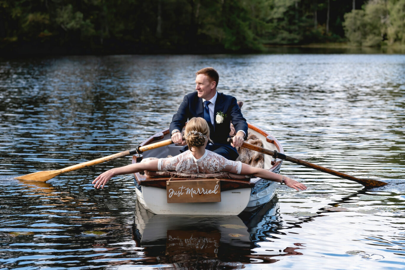 Bride and groom enjoying a rowing boat trip together on the lake at Gilpin Lake House on their wedding day.