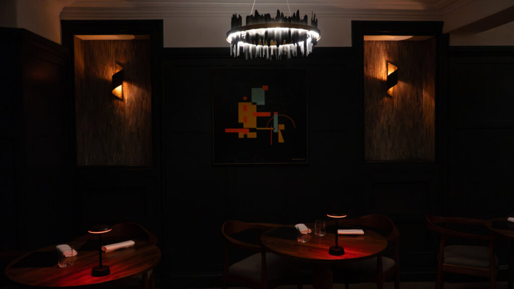 SOURCE dining room at Gilpin Hotel, with intimate tables, dark interiors and warm ambient lighting.