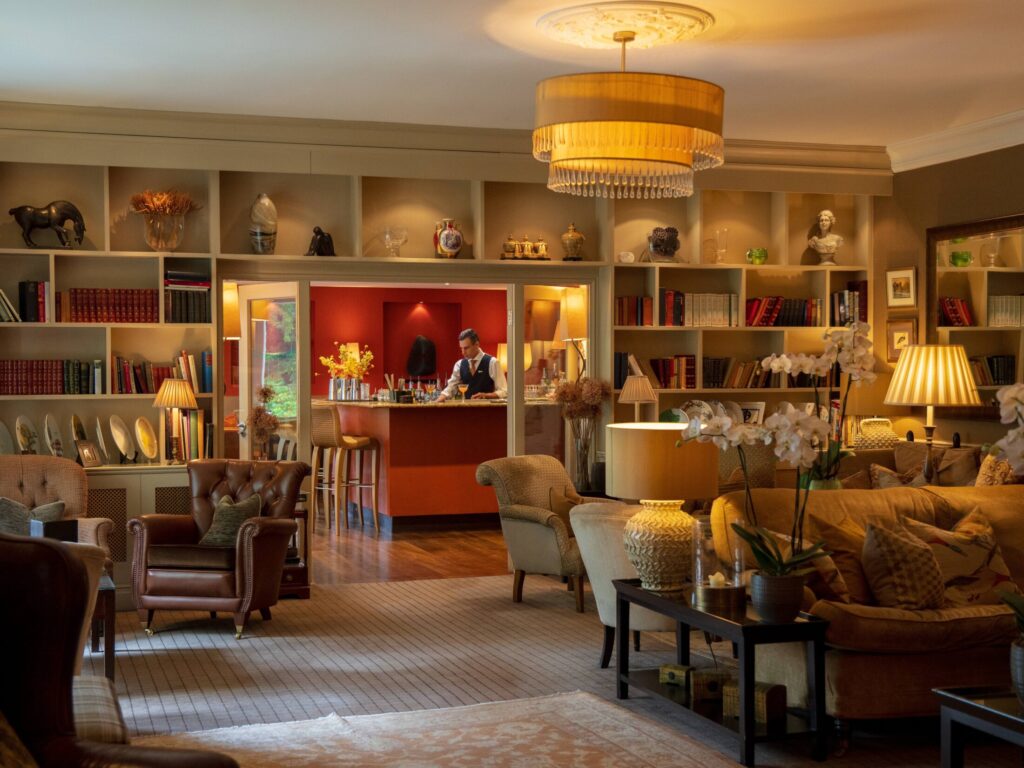 Cosy lounge at Gilpin Hotel with comfortable seating, warm lighting and a welcoming fireside atmosphere.