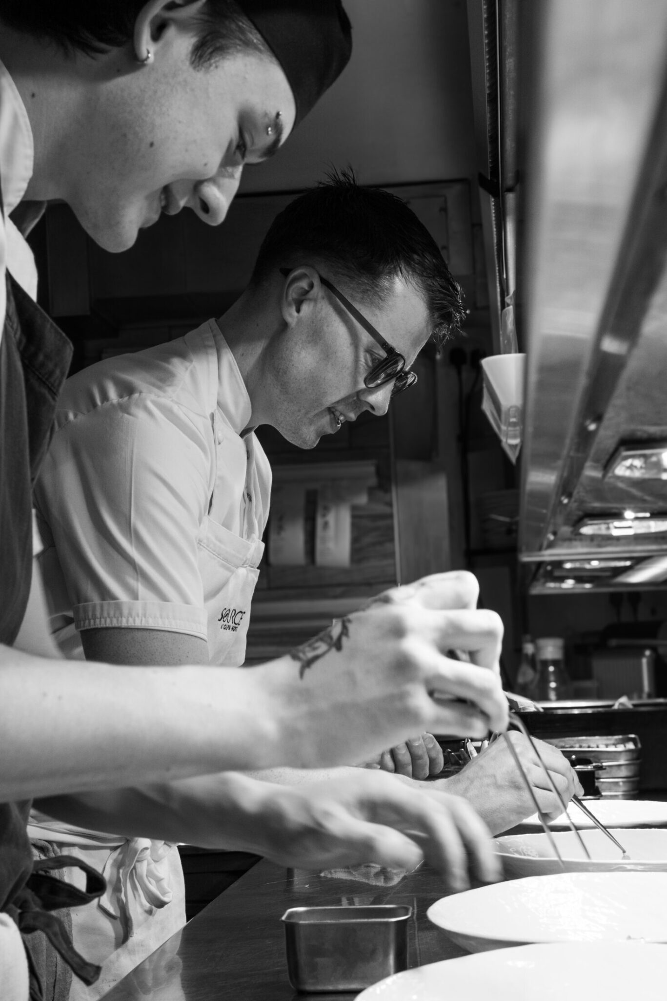 SOURCE chefs working together to plate dishes in the kitchen at Gilpin Hotel.