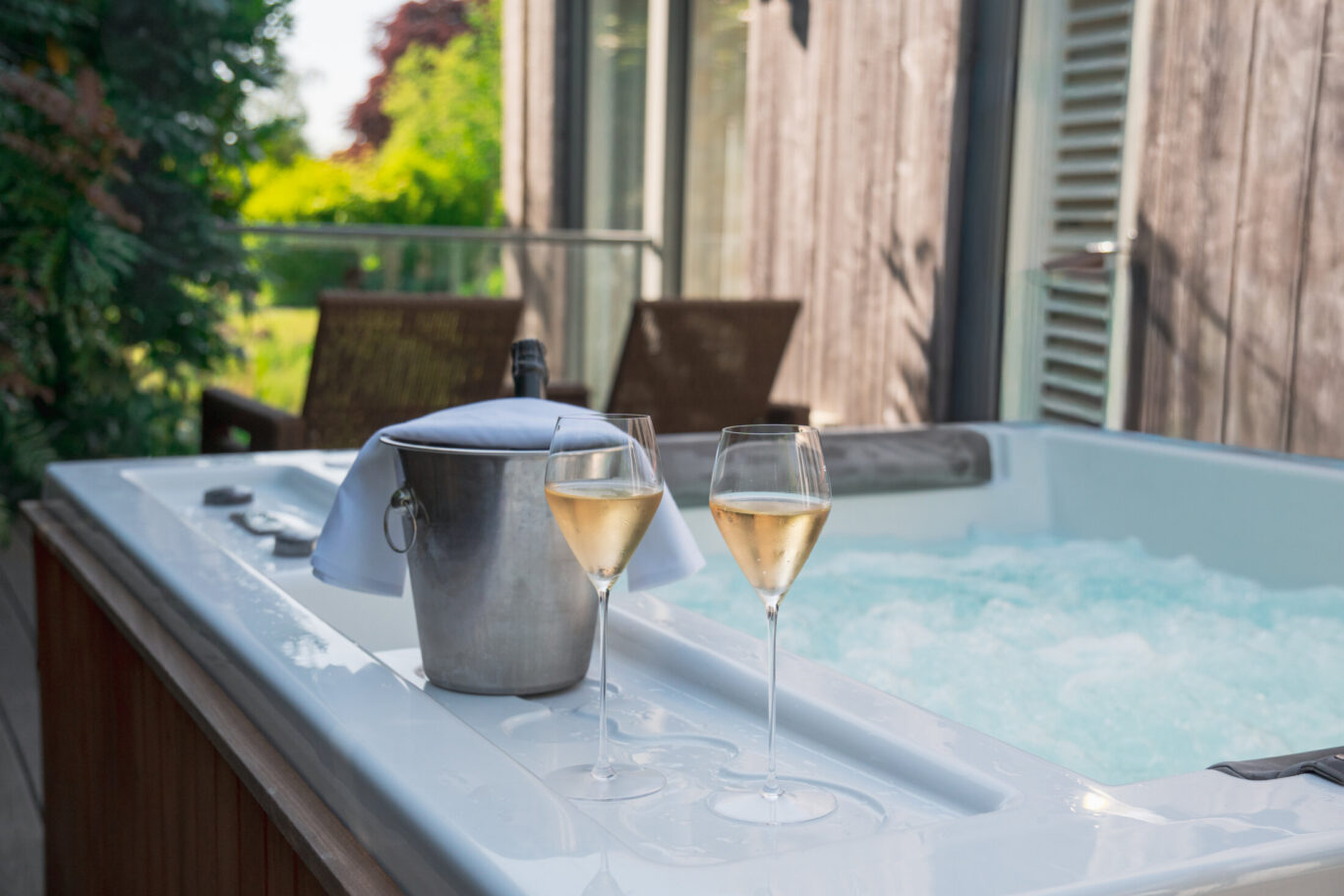 Private outdoor hot tub at Gilpin with two glasses of Champagne and an ice bucket ready beside the water.