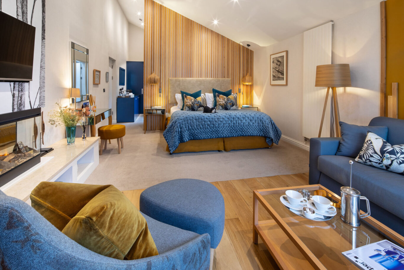 Garden Suite at Gilpin Hotel with a blue quilted bed, floral furnishings and signature cat detail.