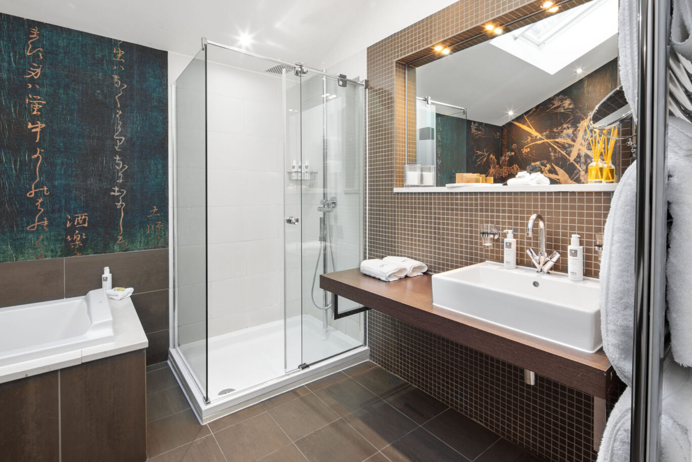 Garden Suite bathroom at Gilpin Hotel with a bath, large walk-in shower and contemporary tiled interiors.