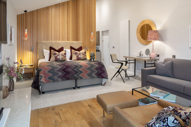 Garden Suite at Gilpin Hotel with a king-size bed, comfortable lounge area and contemporary timber interiors.
