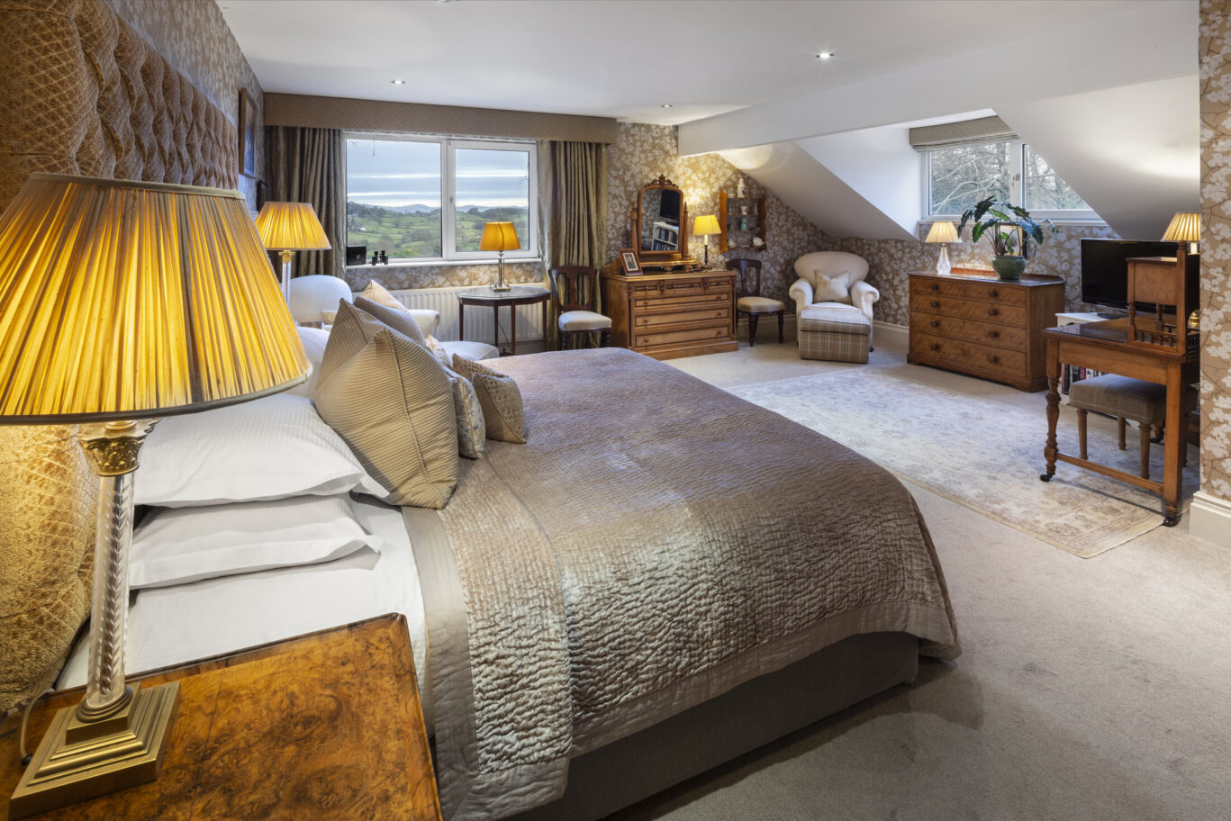 Gertie Room at Gilpin Lake House with a spacious bedroom, comfortable seating area and views across the Lake District countryside.