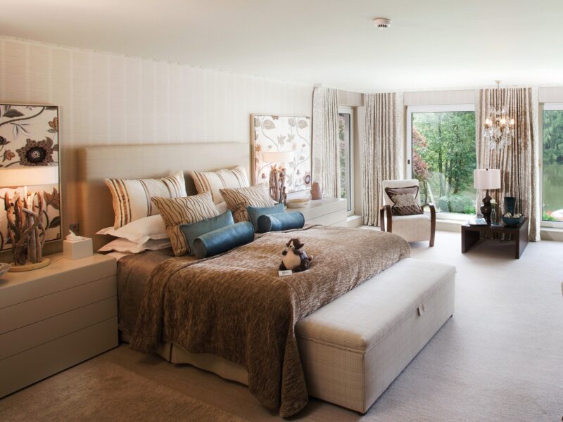 Spacious bedroom at Gilpin Lake House with a king-size bed, comfortable seating area and doors opening onto the gardens.