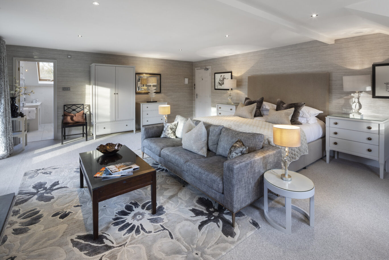 Maud Room at Gilpin Lake House with a spacious bedroom, comfortable sofa and soft neutral furnishings.