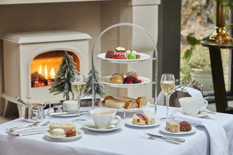 Festive afternoon tea with sandwiches, scones, cakes, tea and Champagne served beside a glowing fire at Gilpin Hotel