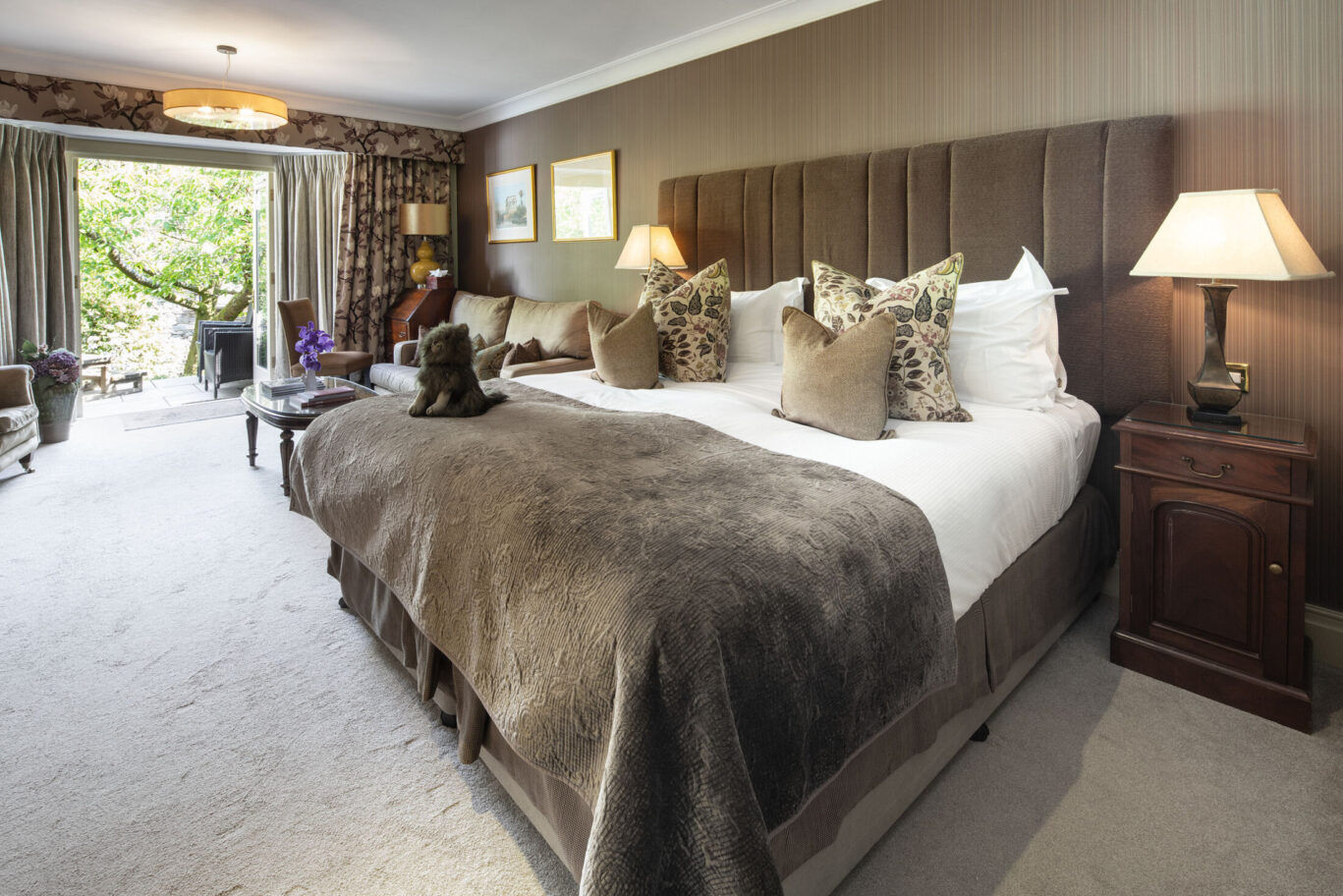 Grasmere Junior Suite at Gilpin Hotel with a king-size bed, spacious seating area and doors opening onto a private terrace.