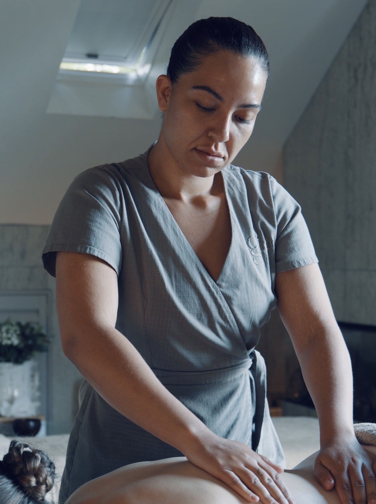 Gilpin Hotel spa therapist giving a guest a back massage in a softly lit treatment room.