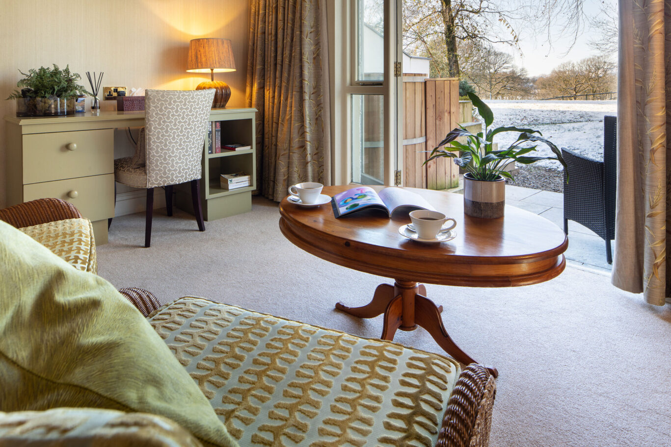 Junior Suite at Gilpin Hotel with lounge seating, writing desk and doors opening onto a private terrace with hot tub.