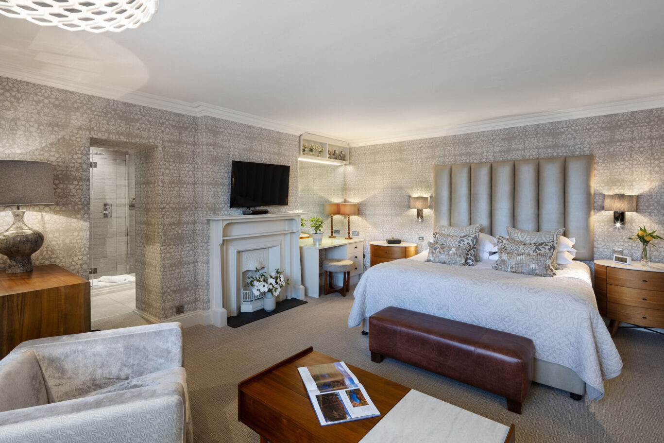 Cleabarrow Master Room at Gilpin Hotel with a king-size bed, elegant neutral décor, seating area and feature fireplace.