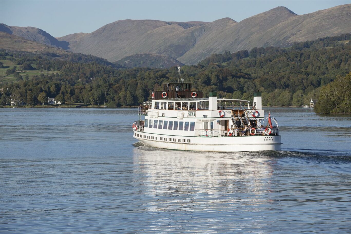 Traditional steamer cruising across Lake Windermere, surrounded by the fells and wooded landscape of the Lake District.