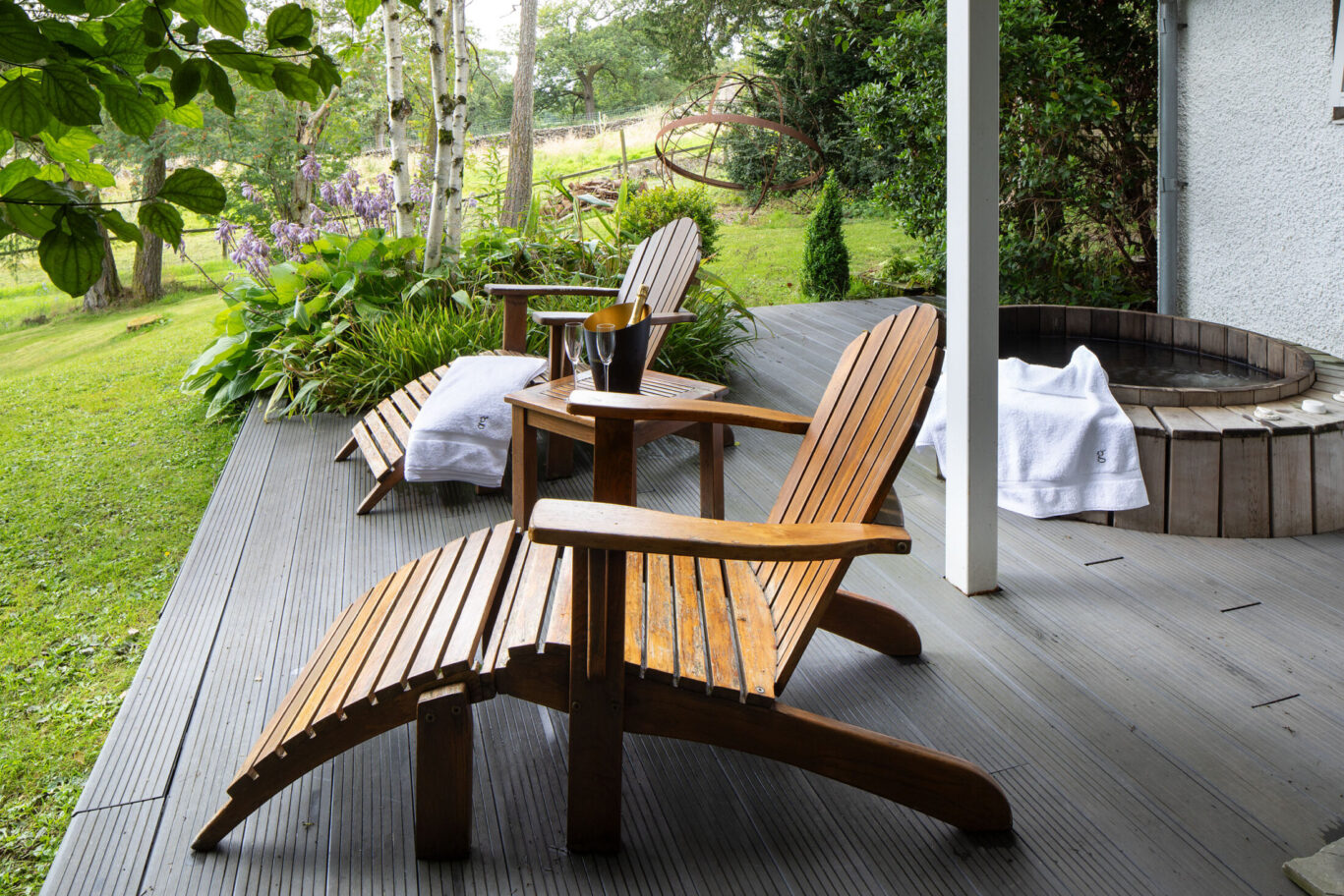 Private terrace at the St Sunday Crag Garden Suite at Gilpin Hotel with outdoor seating, garden views and a cedarwood hot tub.