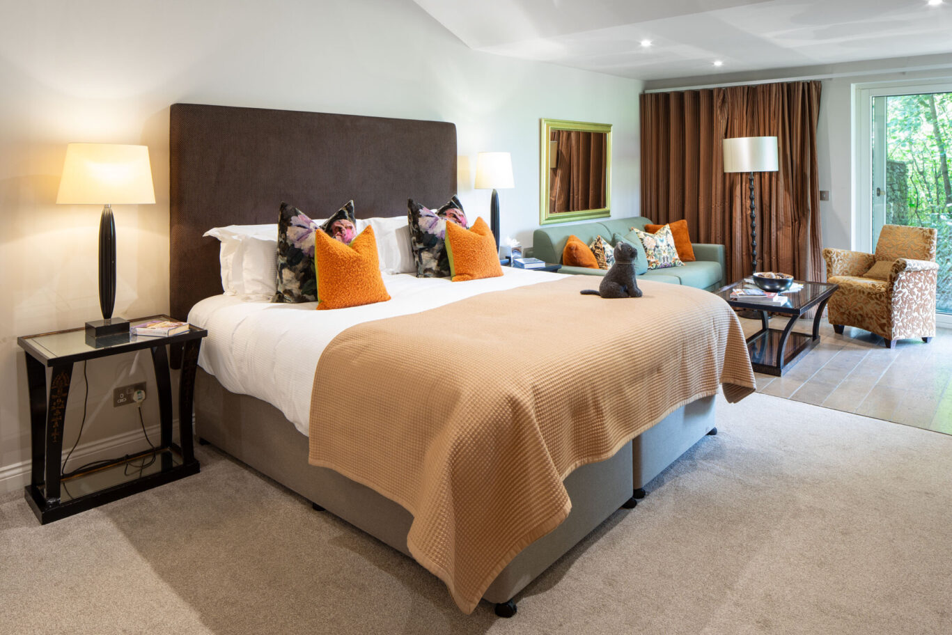 Spacious St Sunday Crag Garden Suite at Gilpin Hotel with a king-size bed and relaxing seating area overlooking the garden.