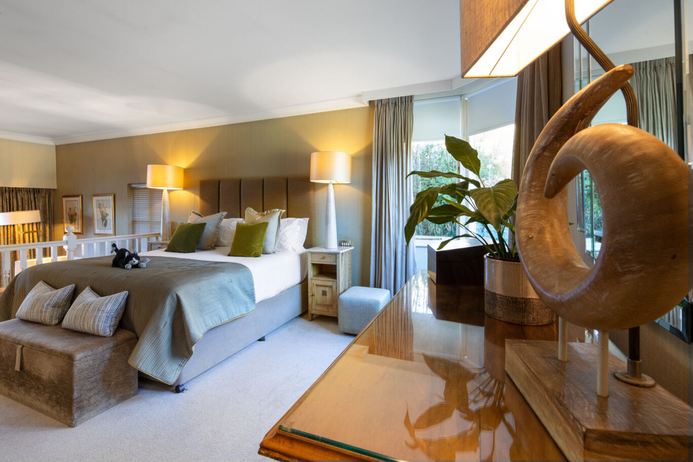 Junior Suite at Gilpin Hotel with a king-size bed, warm neutral interiors and views over the surrounding gardens.
