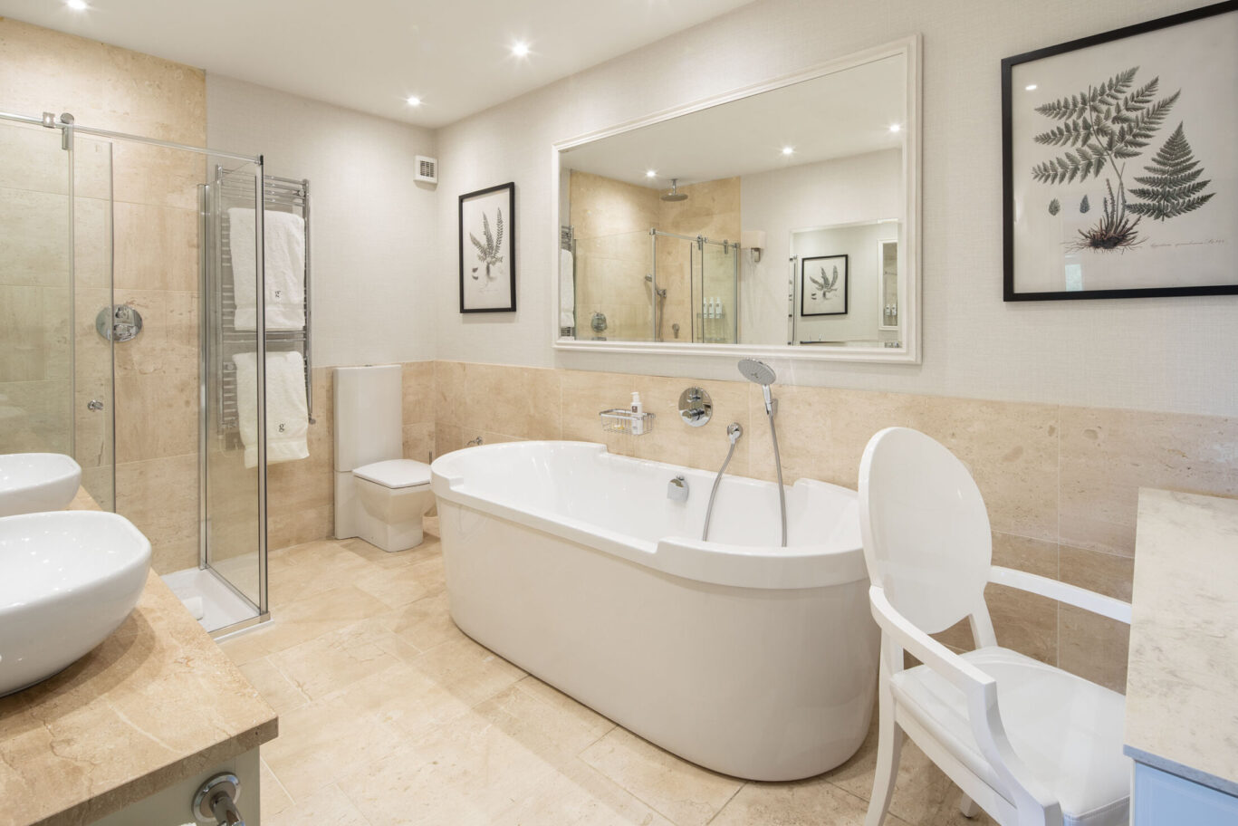Spa Suite bathroom at Gilpin Lake House with a freestanding bath, walk-in shower and soft neutral stone finishes.