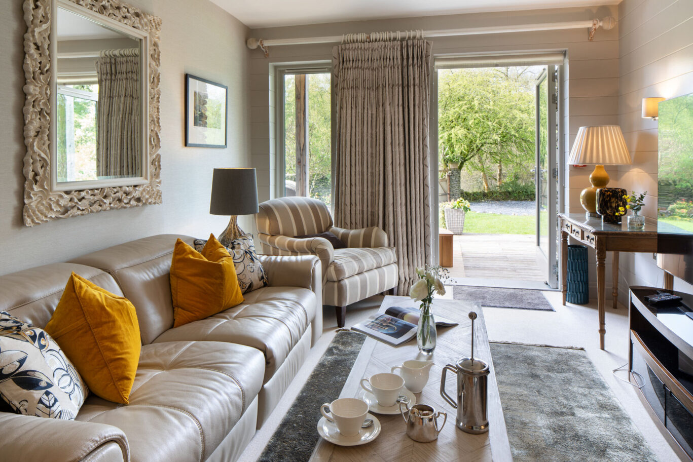 Spa Suite lounge at Gilpin Lake House with comfortable seating, coffee set and doors opening onto a private garden terrace.