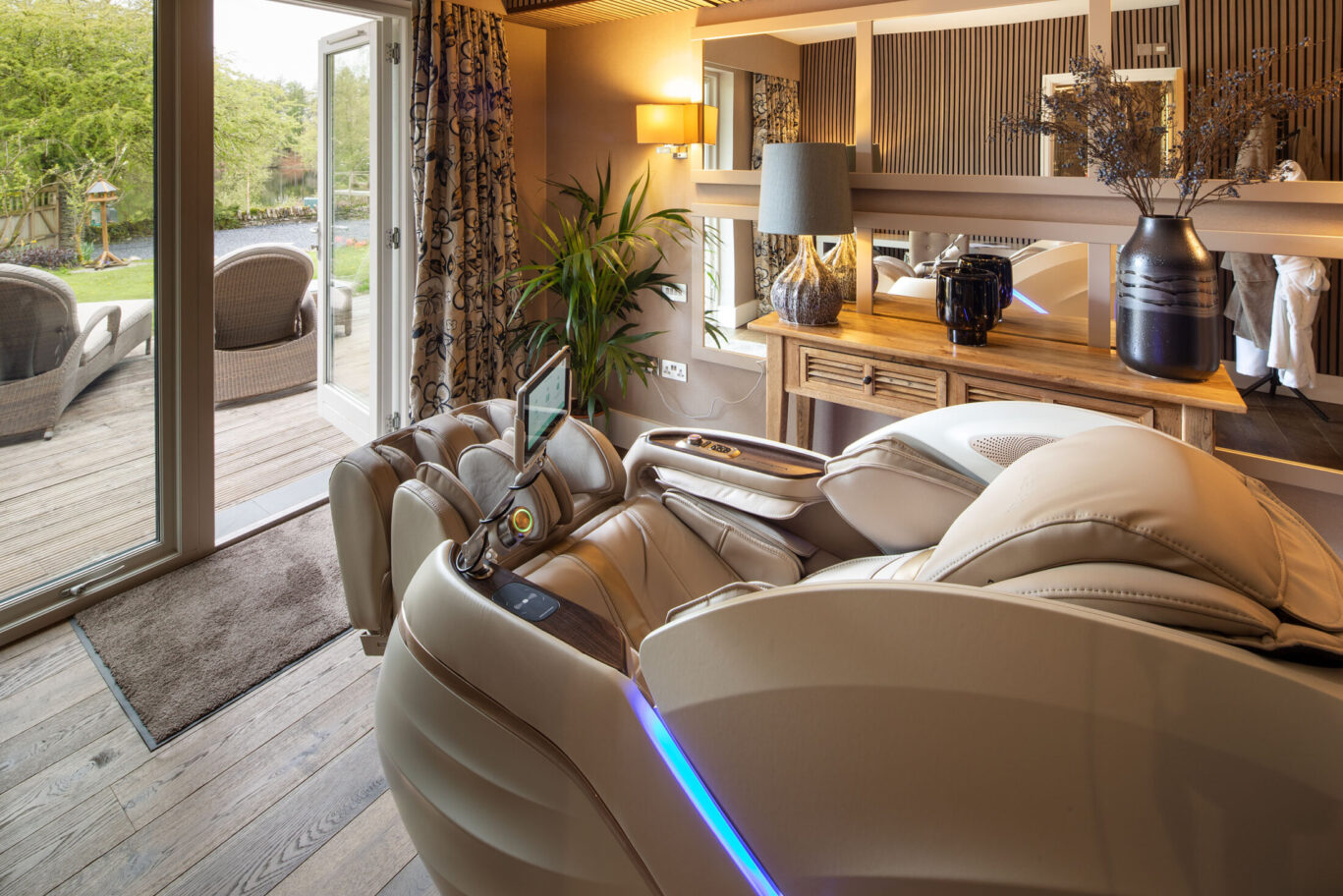 Spa room at Gilpin Lake House with luxury massage chairs, warm wood interiors and doors opening onto a private terrace.