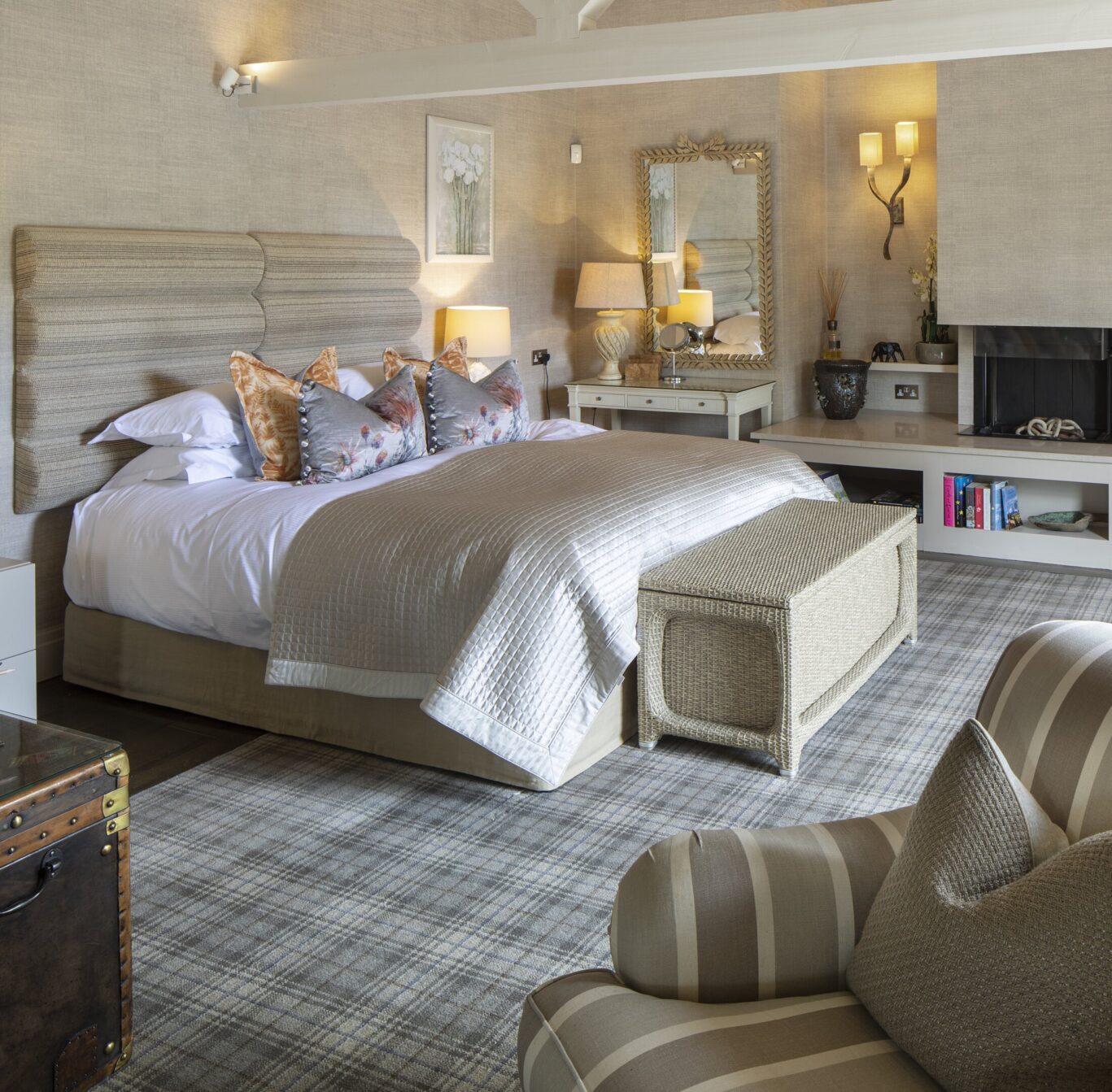 Luxury bedroom at Gilpin Lake House with a king-size bed, fireplace, comfortable seating and warm neutral décor.