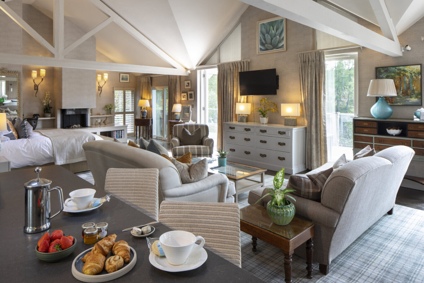 Luxury bedroom at Gilpin Lake House with a king-size bed, fireplace, comfortable seating and warm neutral décor.