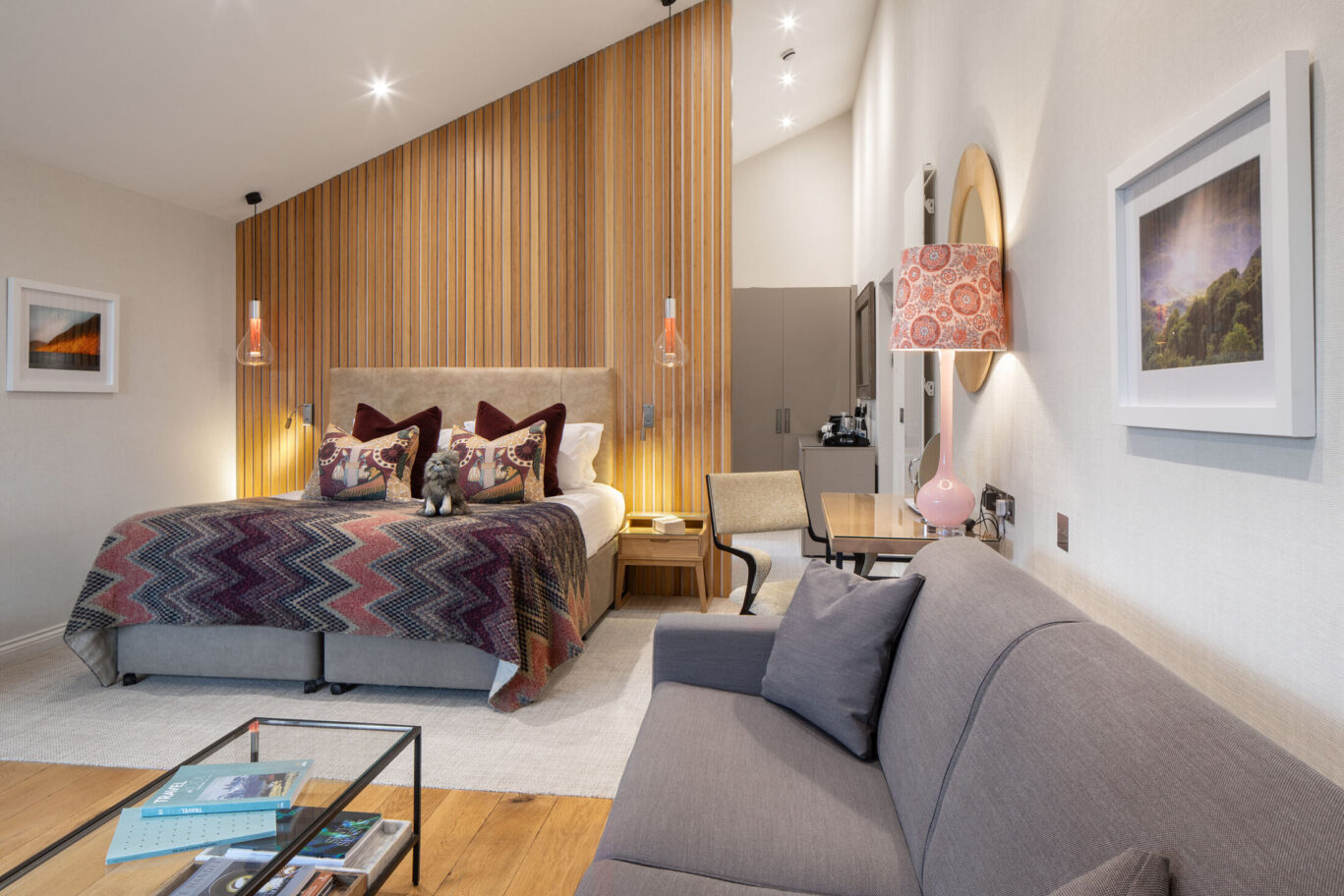 Spacious Garden Suite at Gilpin Hotel with a king-size bed, sofa and warm timber feature wall.
