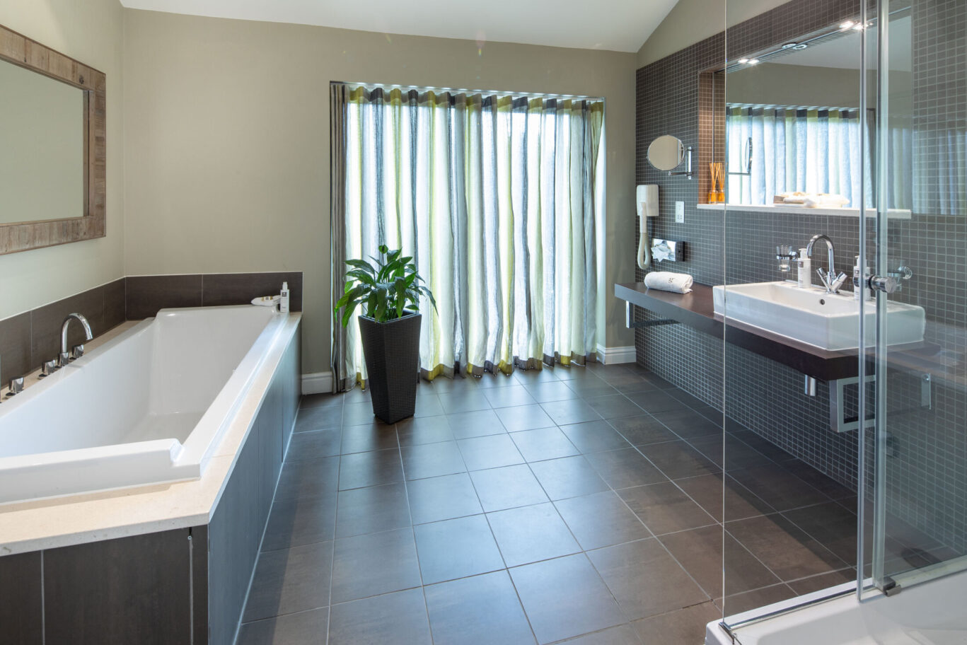 Spacious Garden Suite bathroom at Gilpin Hotel with a large bath, walk-in shower and modern vanity area.