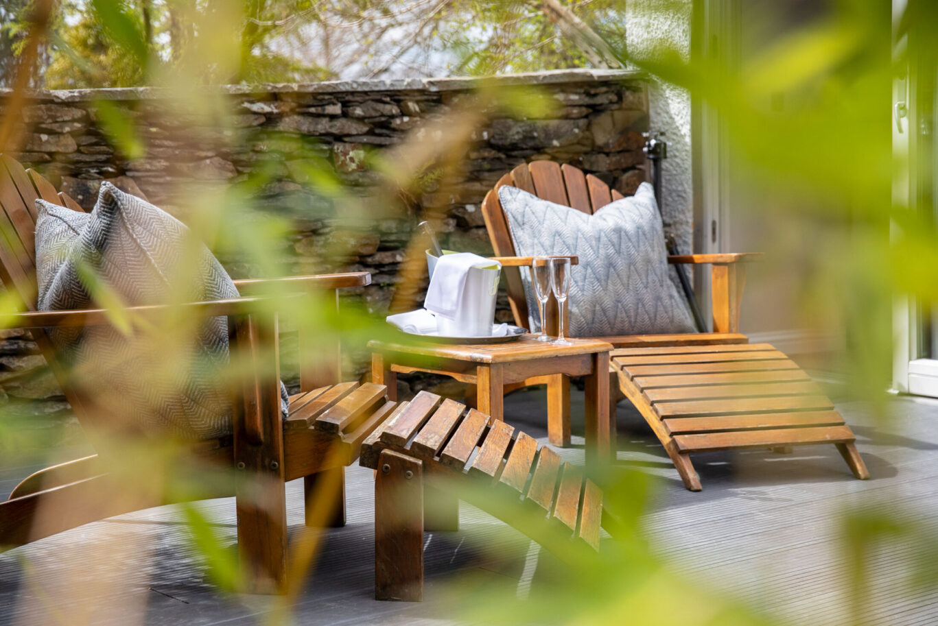 Private Garden Suite terrace at Gilpin Hotel with wooden loungers, champagne and secluded outdoor seating.