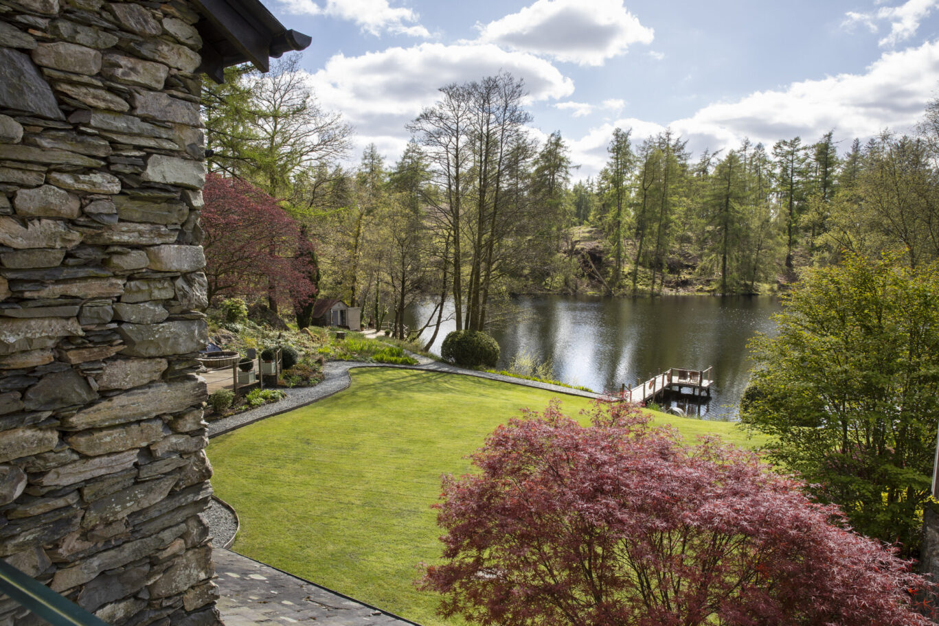 View from Gilpin Lake House across the landscaped lawn to the private lake, surrounded by woodland.