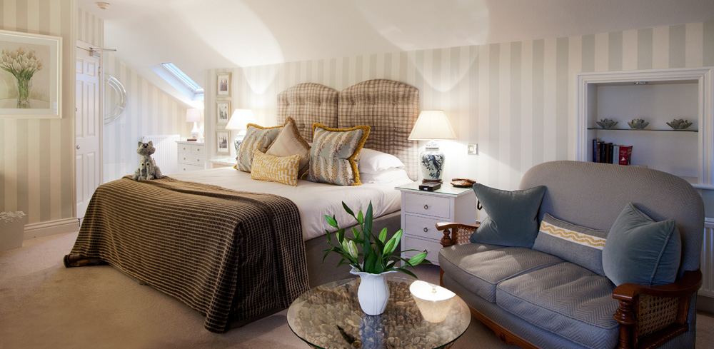 Wetherlam Master Room at Gilpin Hotel with a king-size bed, comfortable seating area and soft neutral décor.