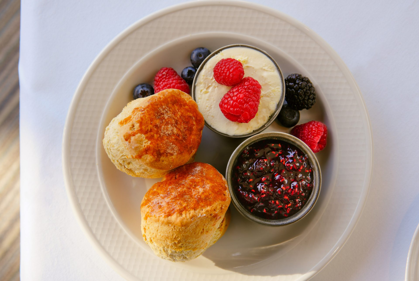 Freshly baked scones served with clotted cream, berries and preserves at Gilpin Hotel.