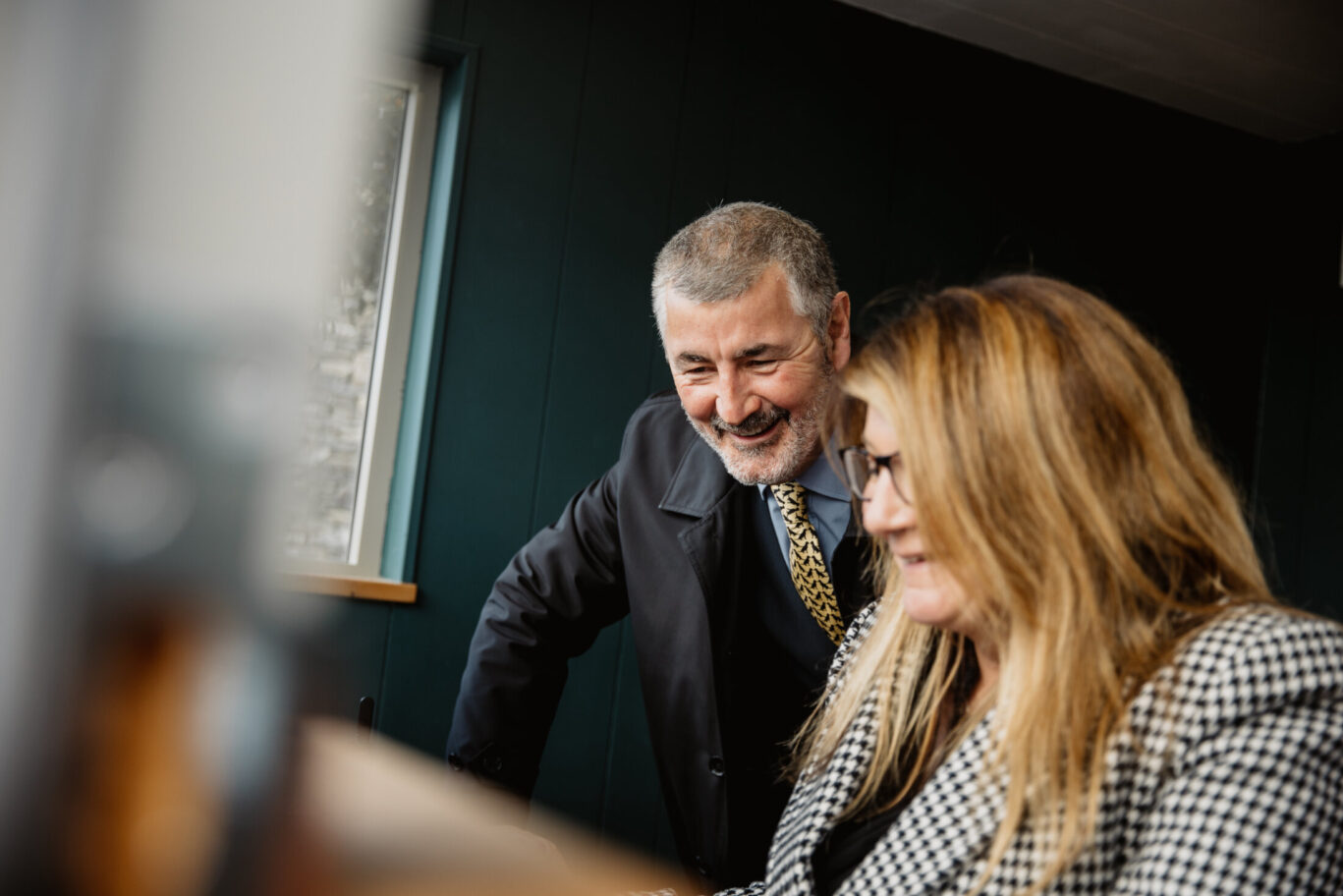A man and woman from Gilpin’s reservations team smiling together while looking at a computer screen.