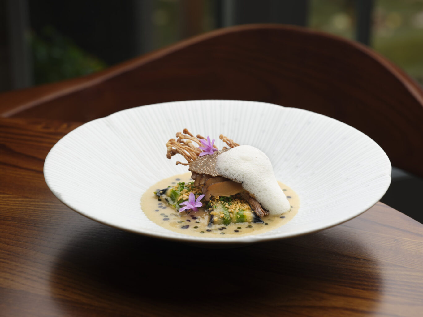 Pasta dish at SOURCE, elegantly presented with a creamy sauce, edible flowers and delicate garnish.